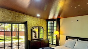 Quarto com uma cama grande, penteadeira, espelho e janela.