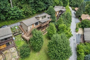 Un quartier résidentiel avec une maison dotée d’une terrasse, d’un escalier et d’un petit jardin.