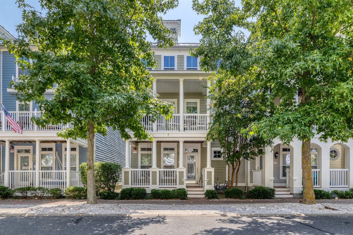 A two-story building with a balcony, a front porch, and a flag.