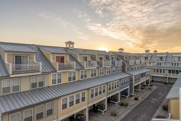 A row of multi-story buildings with balconies and a central courtyard.