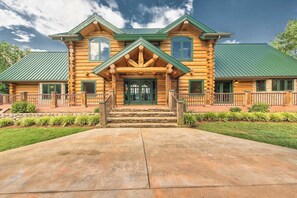 A log cabin with a green roof, a stone staircase leading to the front door, and a well-maintained front yard. - Azalea Retreat- The Lodge by Avantstay Best View (Sherrills Ford)