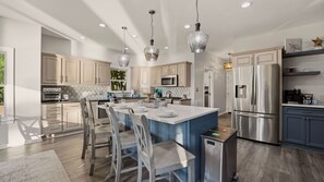 A modern kitchen with a central island, stainless steel appliances, and pendant lighting. - Lakefront Estate Pool + Hot Tub + Dock + Sauna Oasis at Ballycastle (Mooresville)