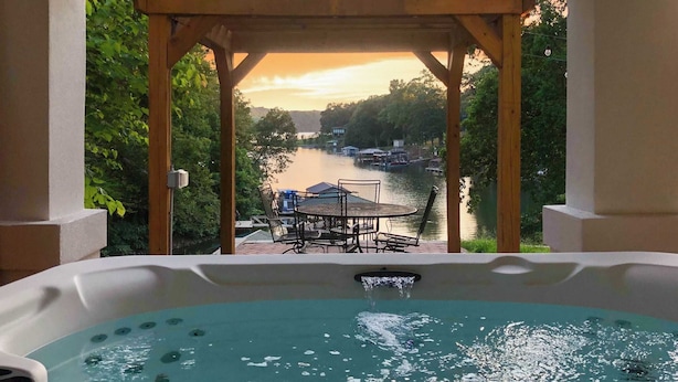 A hot tub with a view of a river and dock area. - Hummingbird Home by Avantstay Hot tub + Sauna (Statesville)