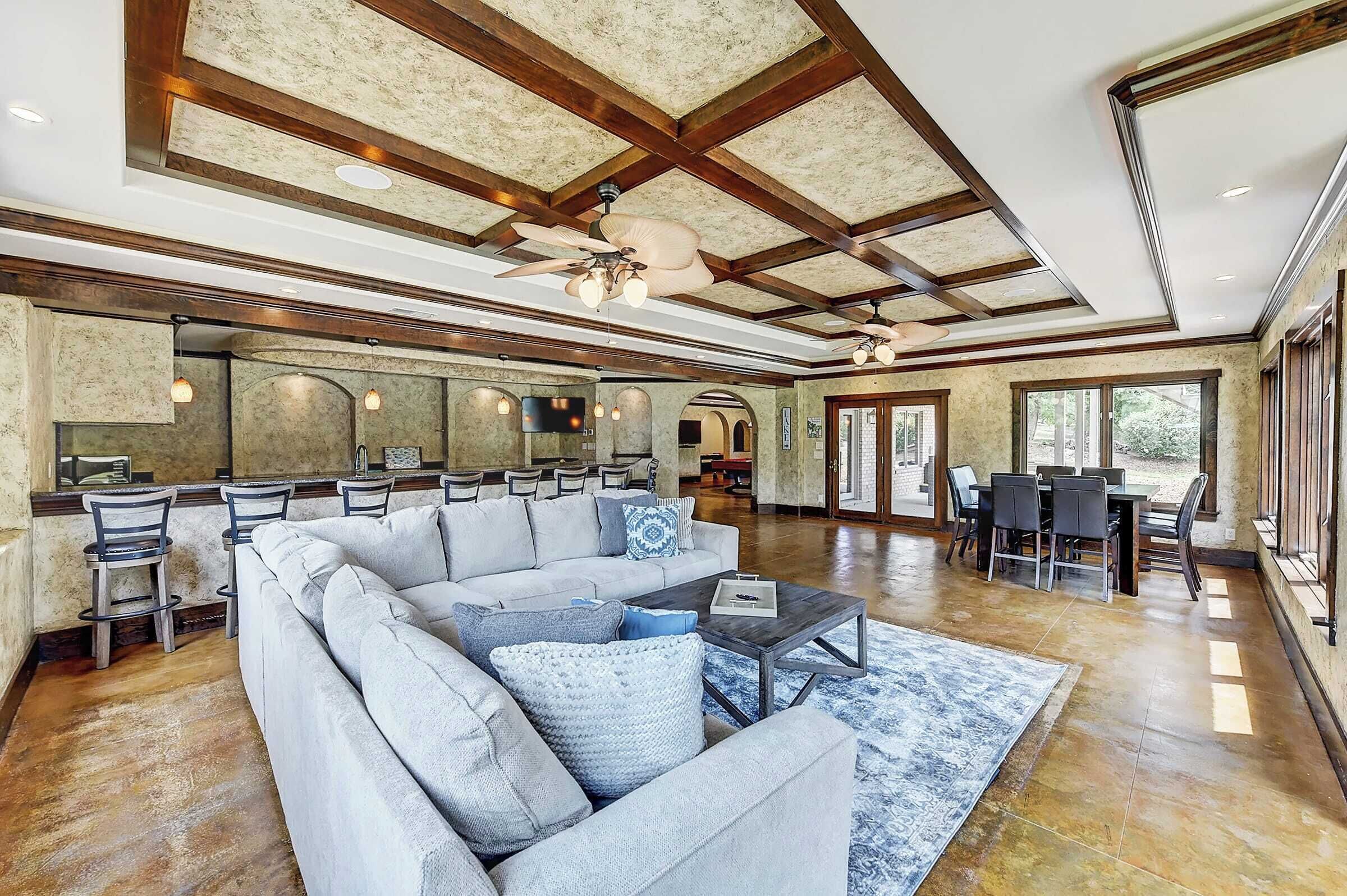 A spacious living room with a sectional sofa, a coffee table, and a dining area with a table and chairs.