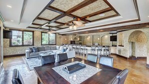 A spacious living area with a large sofa, dining table, and bar seating.