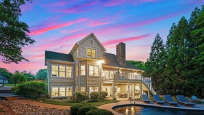 A large, two-story house with a swimming pool, surrounded by trees and a well-maintained garden. - Making Waves by Avantstay Sleeps 20 + Pool (Denver)