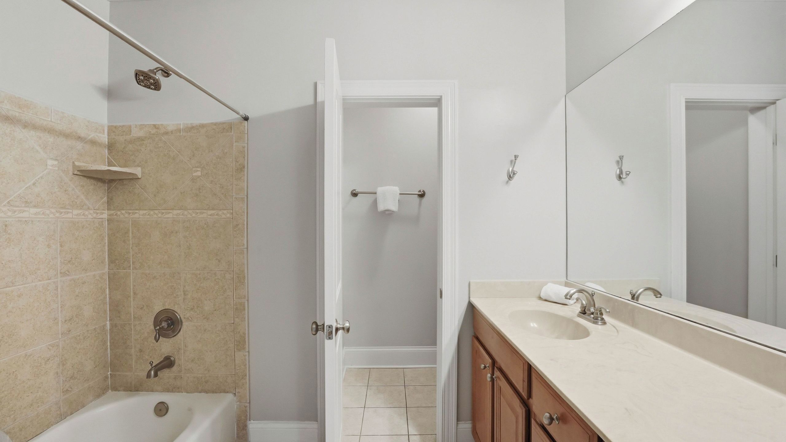 A bathroom with a bathtub, a shower, a sink, and a mirror.
