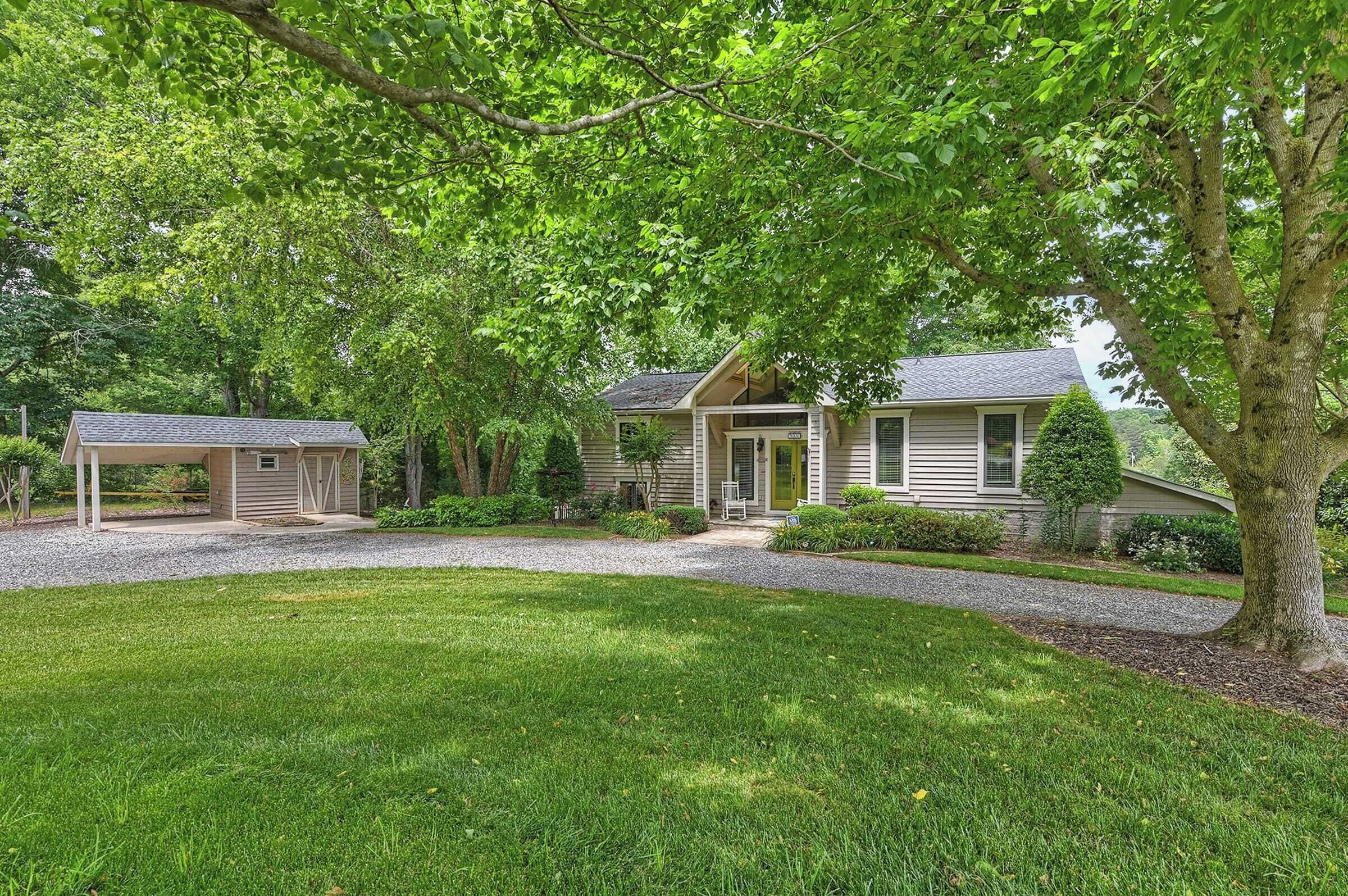 A two-story house with a covered porch, a front yard, and a driveway.