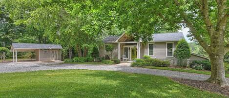 A two-story house with a covered porch, a front yard, and a driveway.