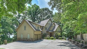 A two-story house with a garage, a driveway, and a well-maintained garden.