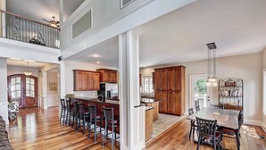A spacious kitchen with wooden cabinets, a central island, and a dining area with a large table and chairs.