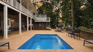 A rectangular pool with steps leading into it, surrounded by outdoor seating and a covered patio area. - Porch Paradise by Avantstay New Pool, Firepit (Mooresville)