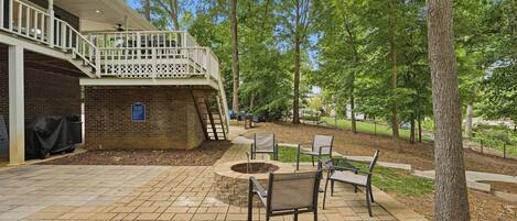 A patio with outdoor seating, a fire pit, and a building with a balcony.