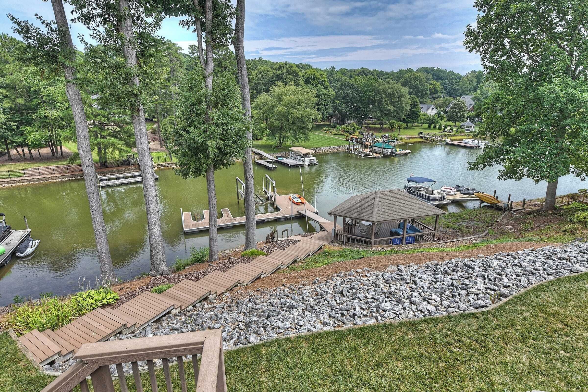 A lakeside property with a dock, a gazebo, and a wooden walkway.