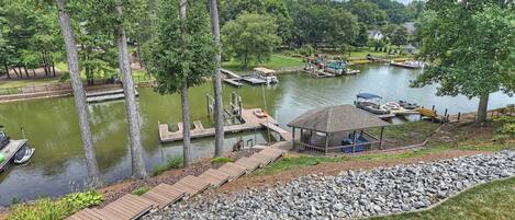 A lakeside property with a dock, a gazebo, and a wooden walkway.