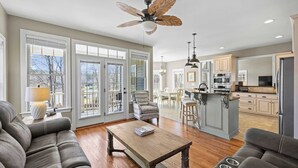 A spacious living room with a wooden coffee table, a gray sofa, and a ceiling fan.