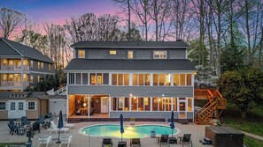 A two-story building with a swimming pool, outdoor seating, and a staircase leading to a deck. - Sleeps 22, Lakefront w/ Private Dock & Pool, 2 Houses Lake Living by Avantstay (Sherrills Ford)
