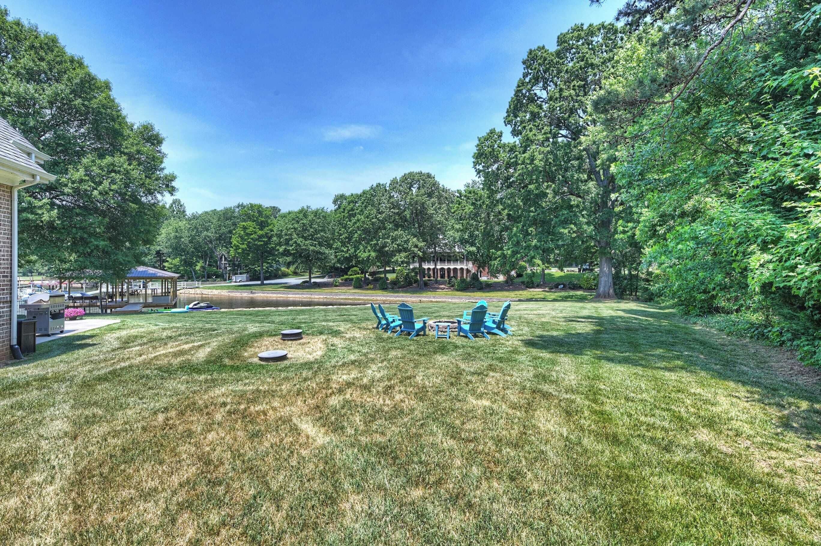 A backyard with a lawn, a gazebo, and outdoor seating.