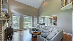 A spacious living room with a sectional sofa, a coffee table, and a fireplace. - Dock Holiday by Avantstay Custom Home + New Dock (Huntersville)