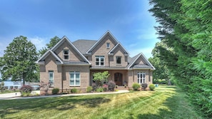 A two-story house with a brick exterior, a front porch, and a well-maintained lawn.