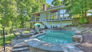 A modern house with a swimming pool, stone steps, and outdoor furniture.