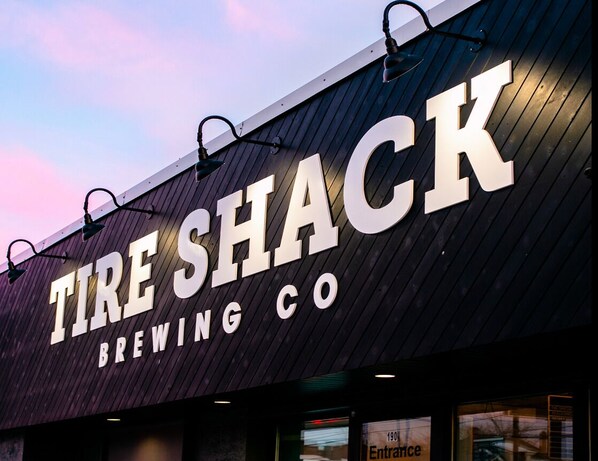 A building with a sign that reads 'TIRE SHACK BREWING CO.' - Studio 3 ~ 1 BDRM Apartment, w/ Lounge Area (Moncton)