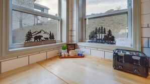 A kitchen with a wooden countertop, a toaster, and a window with a view of a house and trees. - Cozy Condo w/ Balcony & Views in Beech Mountain! (Beech Mountain)
