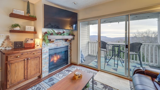 A cozy living room with a fireplace, wooden shelves, and a view of the outdoors. - Cozy Condo w/ Balcony & Views in Beech Mountain! (Beech Mountain)