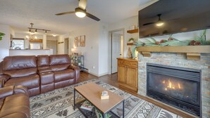 A living room with a fireplace, leather sofa, and a coffee table. - Cozy Condo w/ Balcony & Views in Beech Mountain! (Beech Mountain)