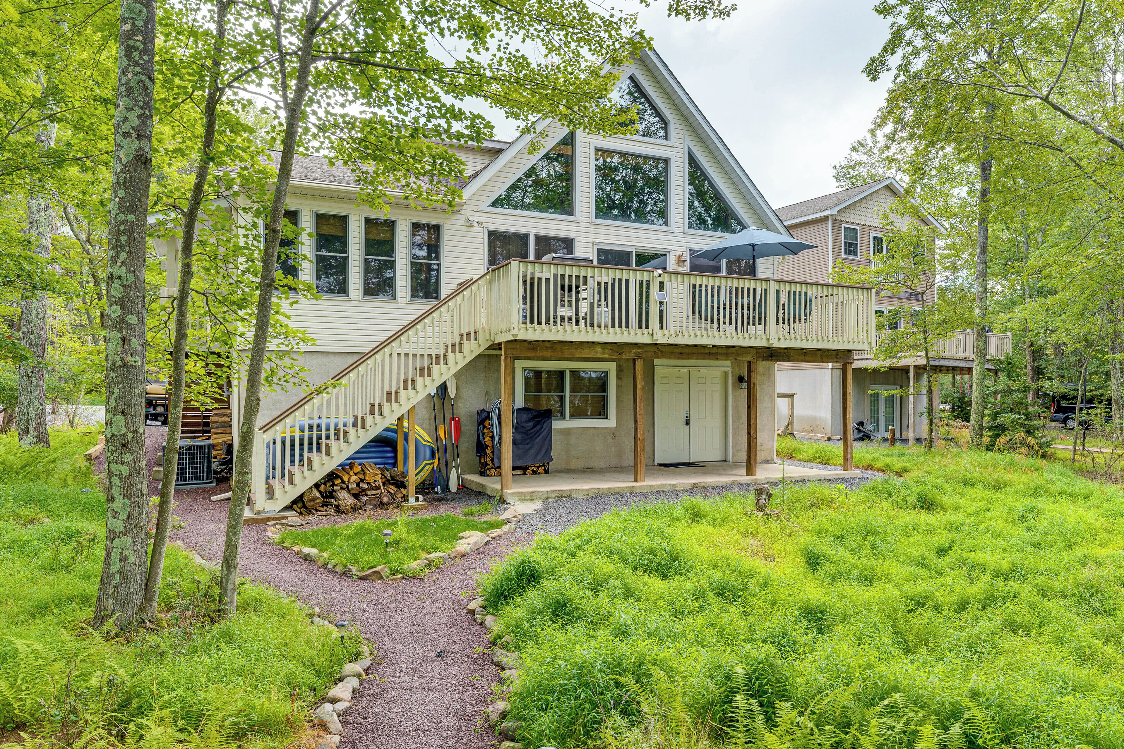 A two-story house with a balcony, a covered porch, and a gravel pathway.