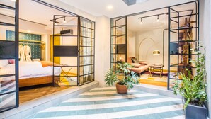 Habitación de hotel moderna con cama, zona de estar y vistas a la ciudad.
