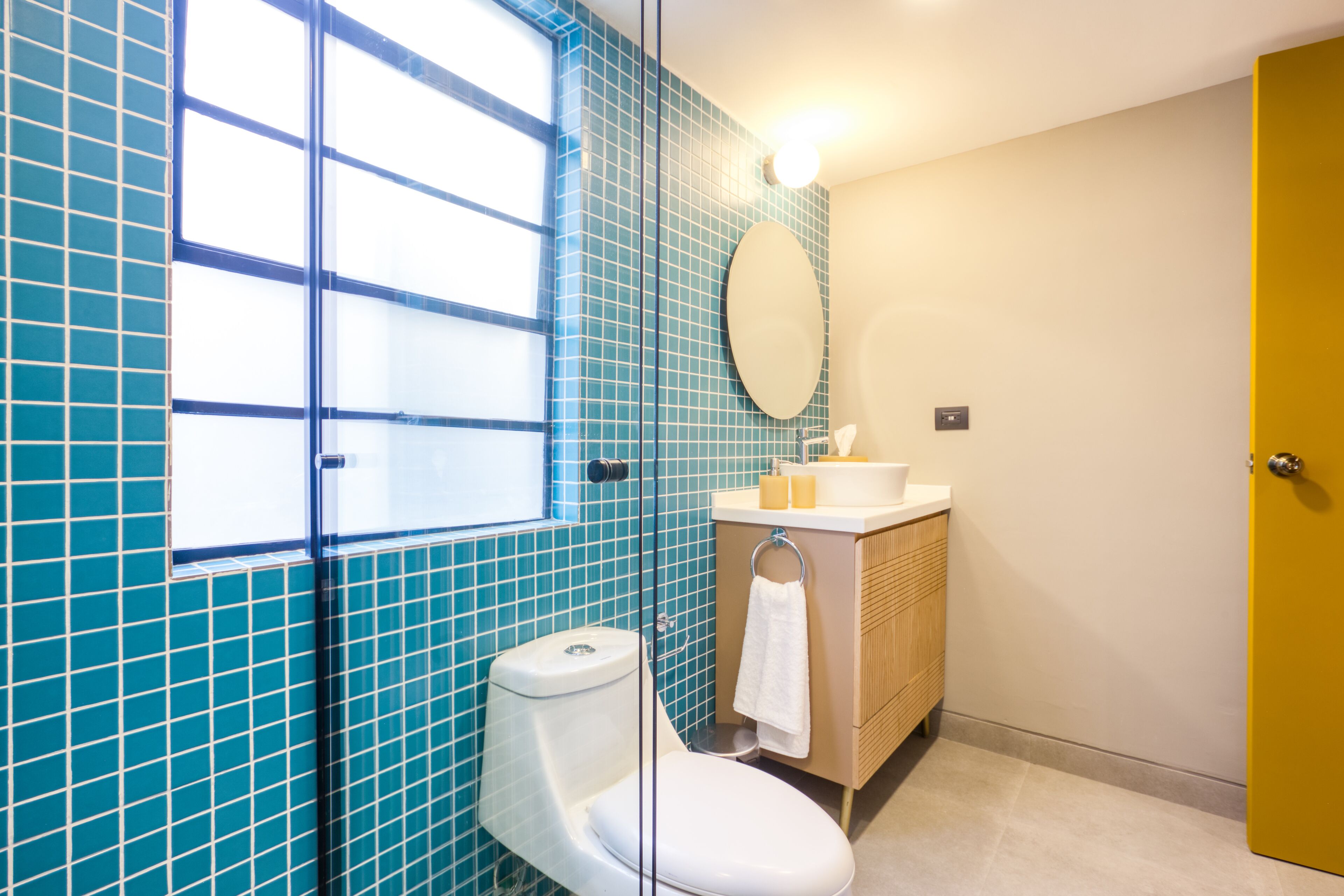 Un baño con inodoro, lavamanos y espejo.