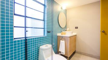 Un baño con inodoro, lavamanos y espejo.