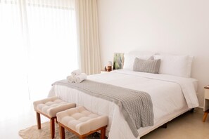 A neatly arranged bedroom with a large bed, a bedside table, and a bench. - Aldrava Pousada Boutique (Tiradentes)