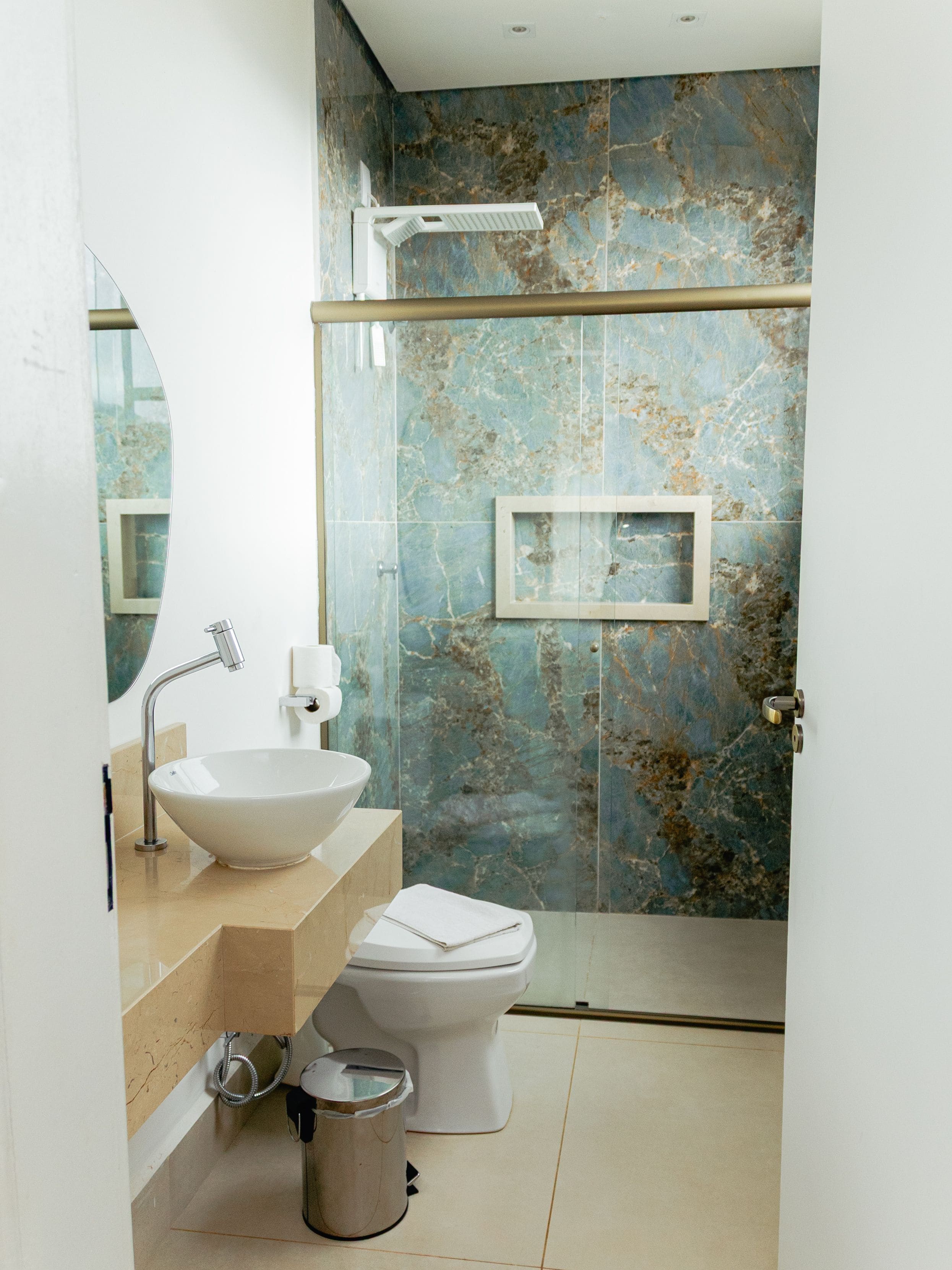 A modern bathroom with a white sink, toilet, and shower.