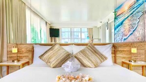A hotel room with a large bed, two nightstands, a mirror, and a painting on the wall. - Waikiki Ocean View Deluxe Studio (Honolulu)
