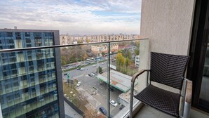 A balcony with a view of a cityscape, including buildings and a parking lot. - Cozy studio with amazing view over the city  (București)
