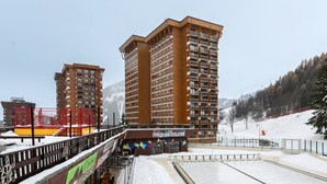 Un hôtel de grande hauteur doté de nombreux balcons, d’un centre de remise en forme et d’une zone desservie par un télésiège.
