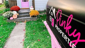 A house with a pink door and a mailbox labeled "Pinky Properties."