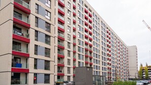 A modern multi-story residential building with a uniform facade, balconies, and a gated entrance. - Cozy studio 1st floor (București)