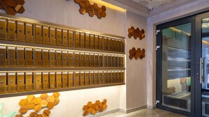 A hotel lobby with multiple rows of lockers, a glass door entrance, and wooden wall decorations. - Cozy studio 1st floor (București)