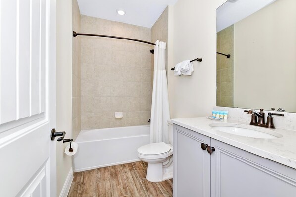 A bathroom with a bathtub, toilet, and sink.