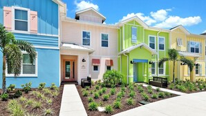 A row of colorful houses with a pathway leading to a bench.