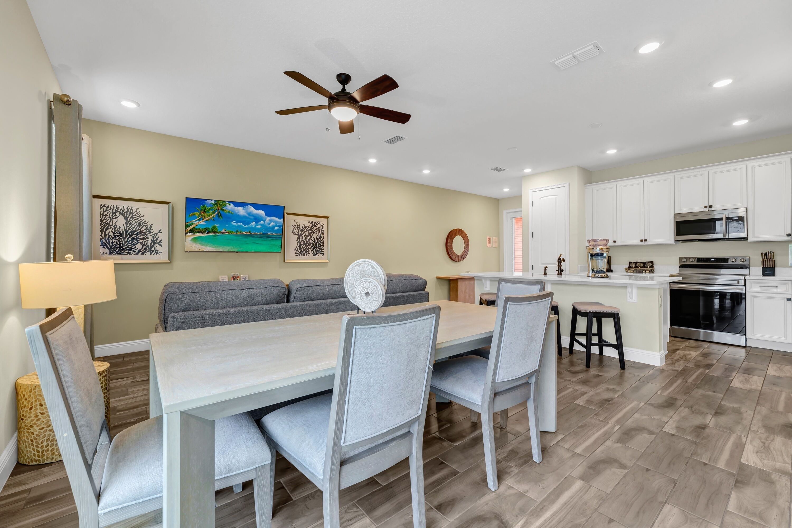 A modern kitchen with white cabinets, a microwave, and an oven.