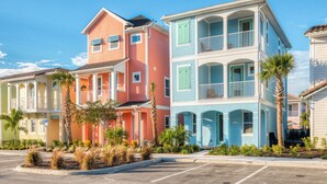 A row of colorful, multi-story buildings with balconies and a parking lot in front. - Spectacular Cottage near Disney w/ Pool & Island H2O Waterpark Access - 8026KD (Kissimmee)