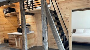 A room with a bunk bed, a desk with a chair, and a staircase. - VRFLX Seneca View Bungalow | Hot Tub Retreat (Burdett)