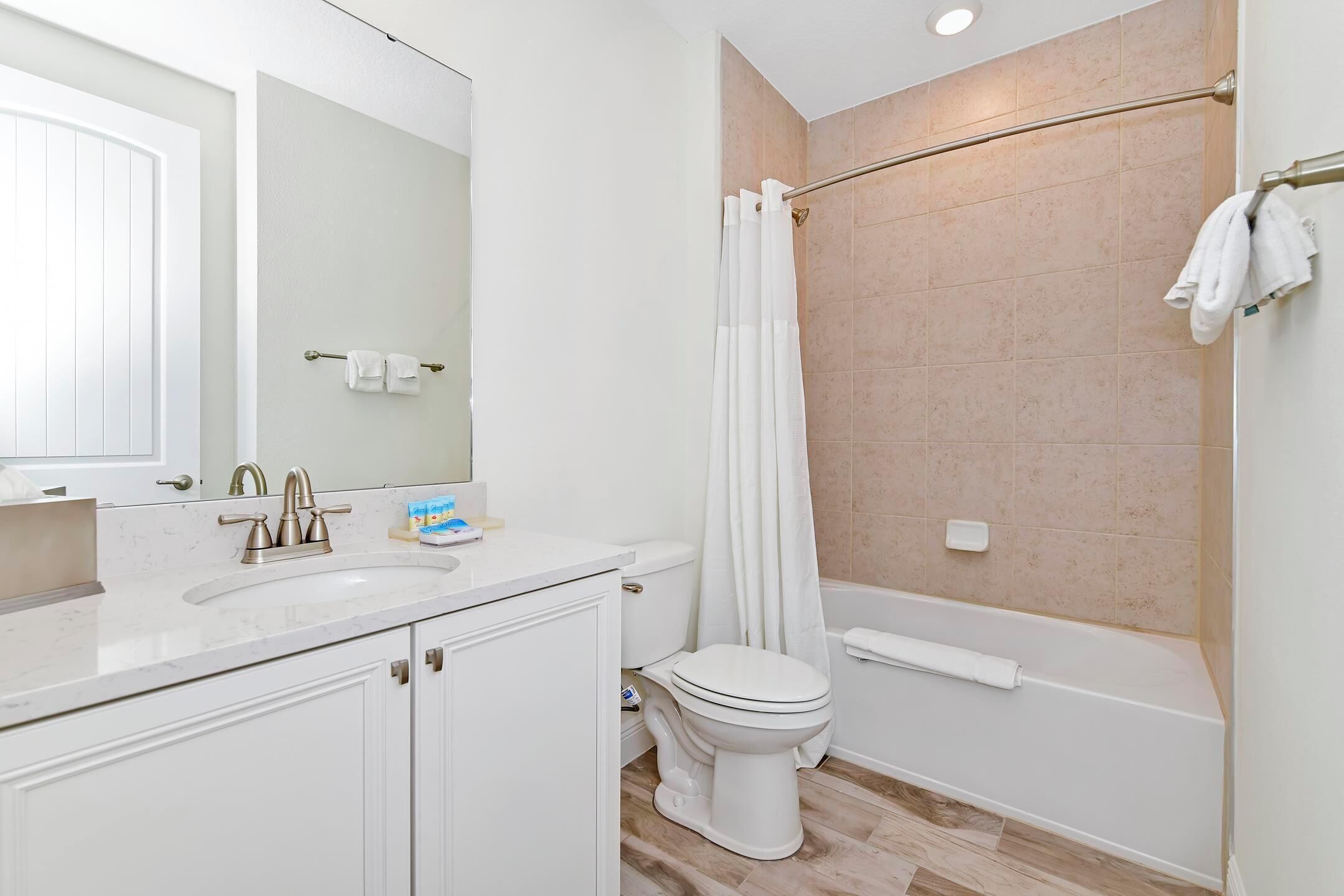 A modern bathroom with a white sink, toilet, and bathtub.