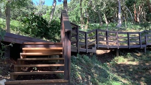 Una escalera de madera que lleva a un puente en un área boscosa.