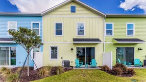 Une rangée de maisons de ville à trois étages, chacune dotée d’un petit patio à l’avant.