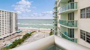 Un hôtel de grande hauteur doté de balcons donnant sur une plage et l’océan.